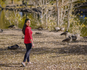 Photo of Paula Pant outdoors surrounded by geese